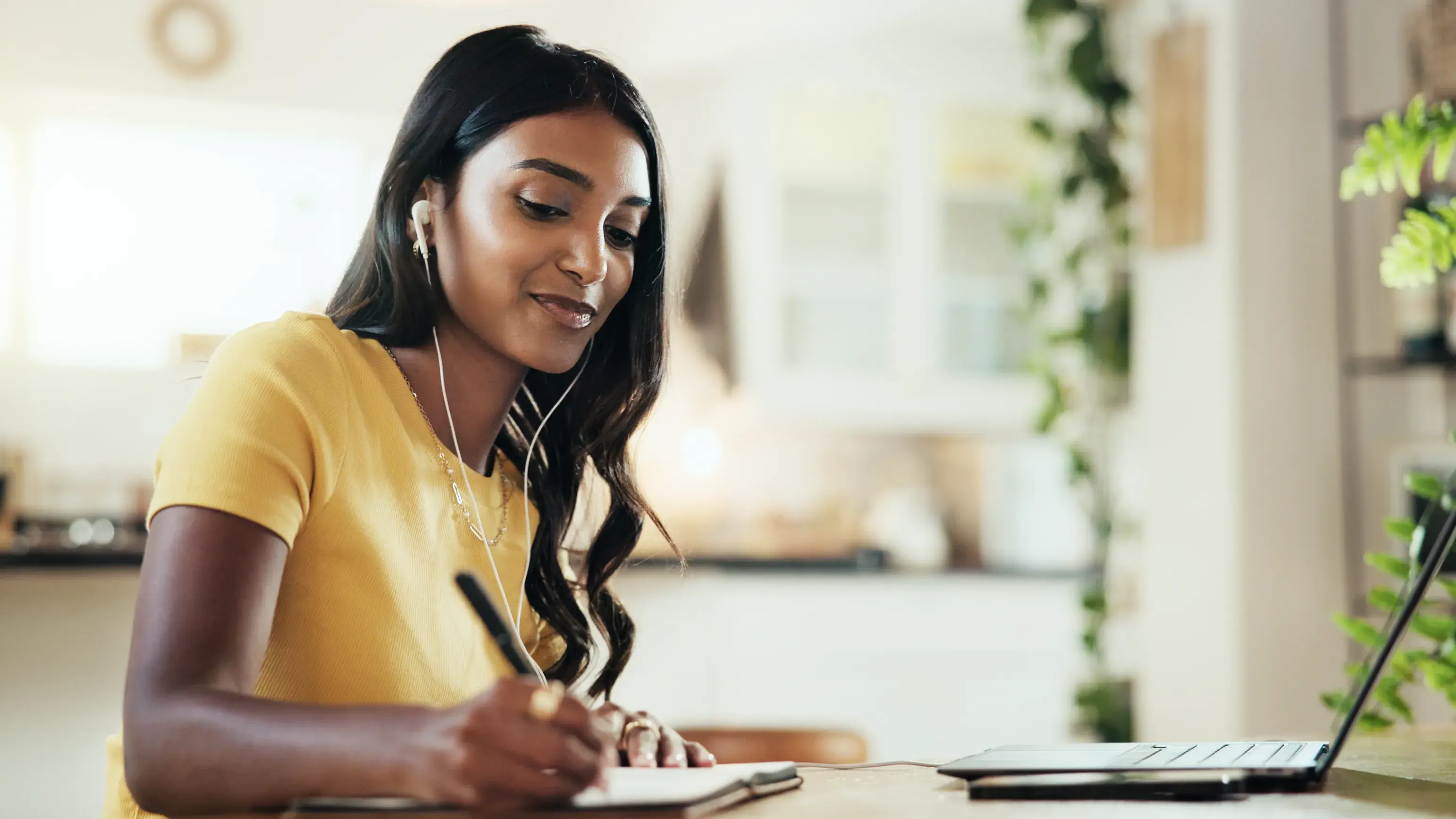 Woman watching Zoom meeting taking notes