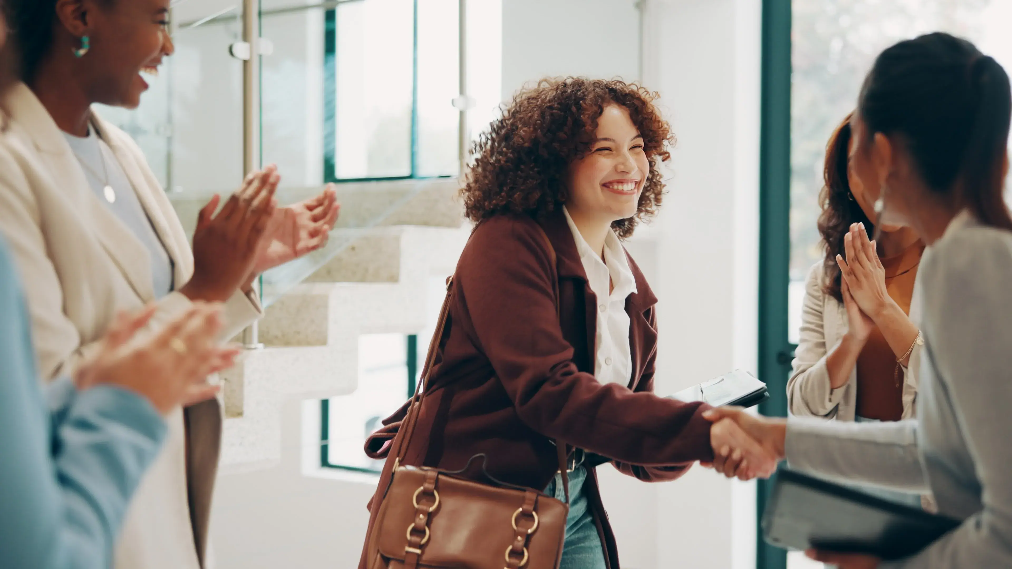 Two women shaking hands in office environment